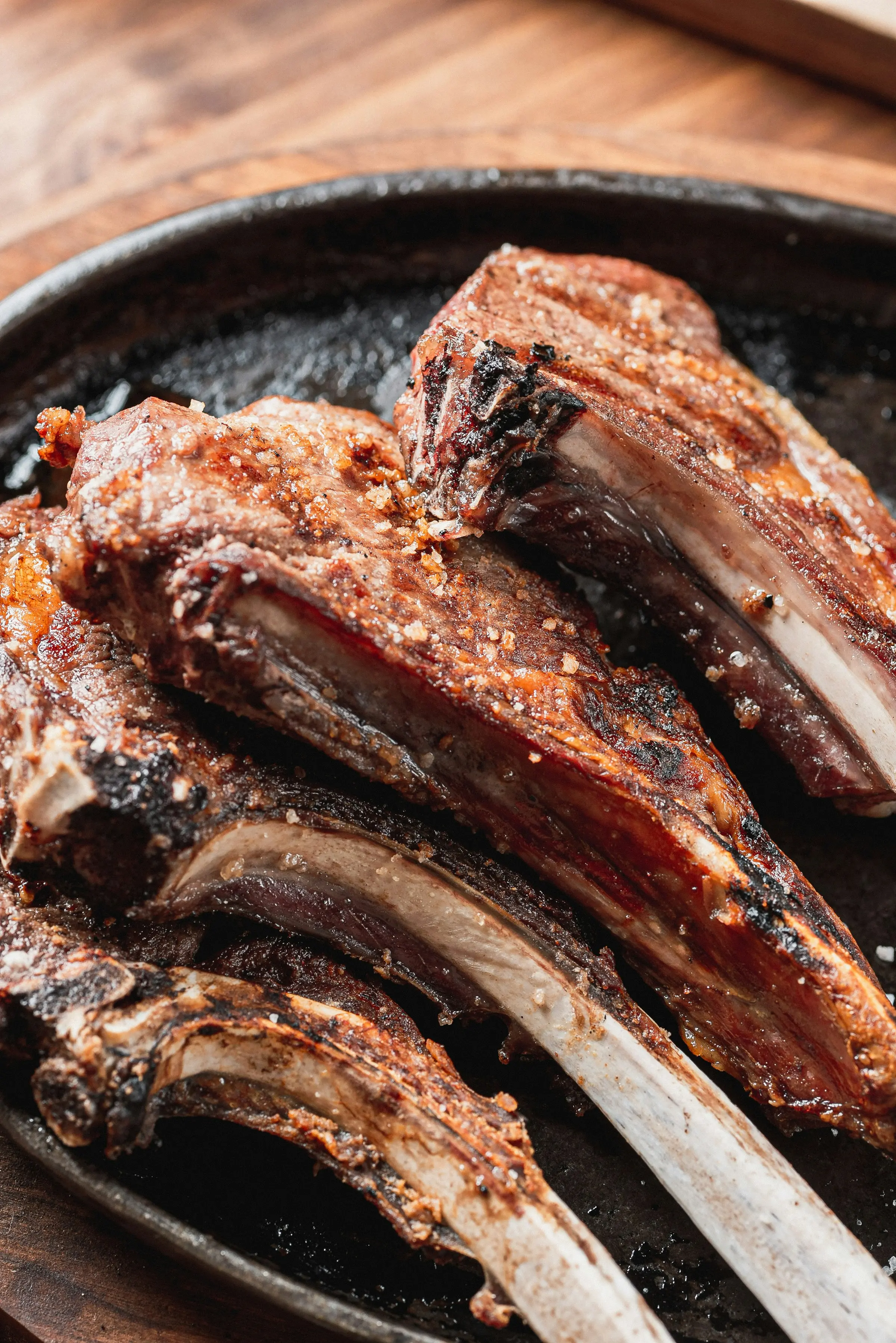 Glazed grilled lamb chops on a dark platter