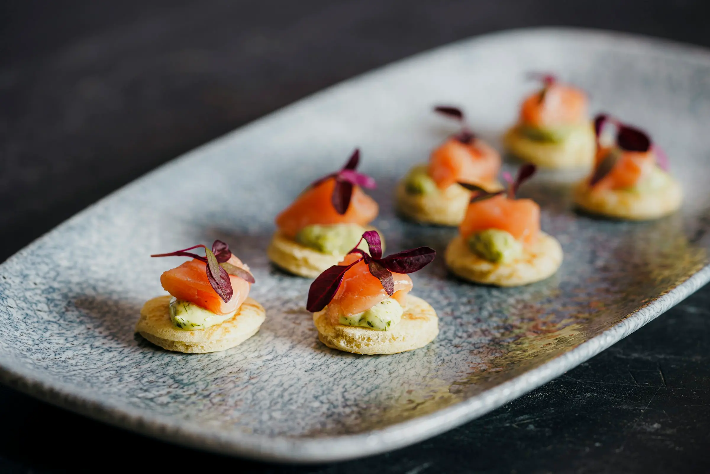 Smoked salmon blinis on a grey platter