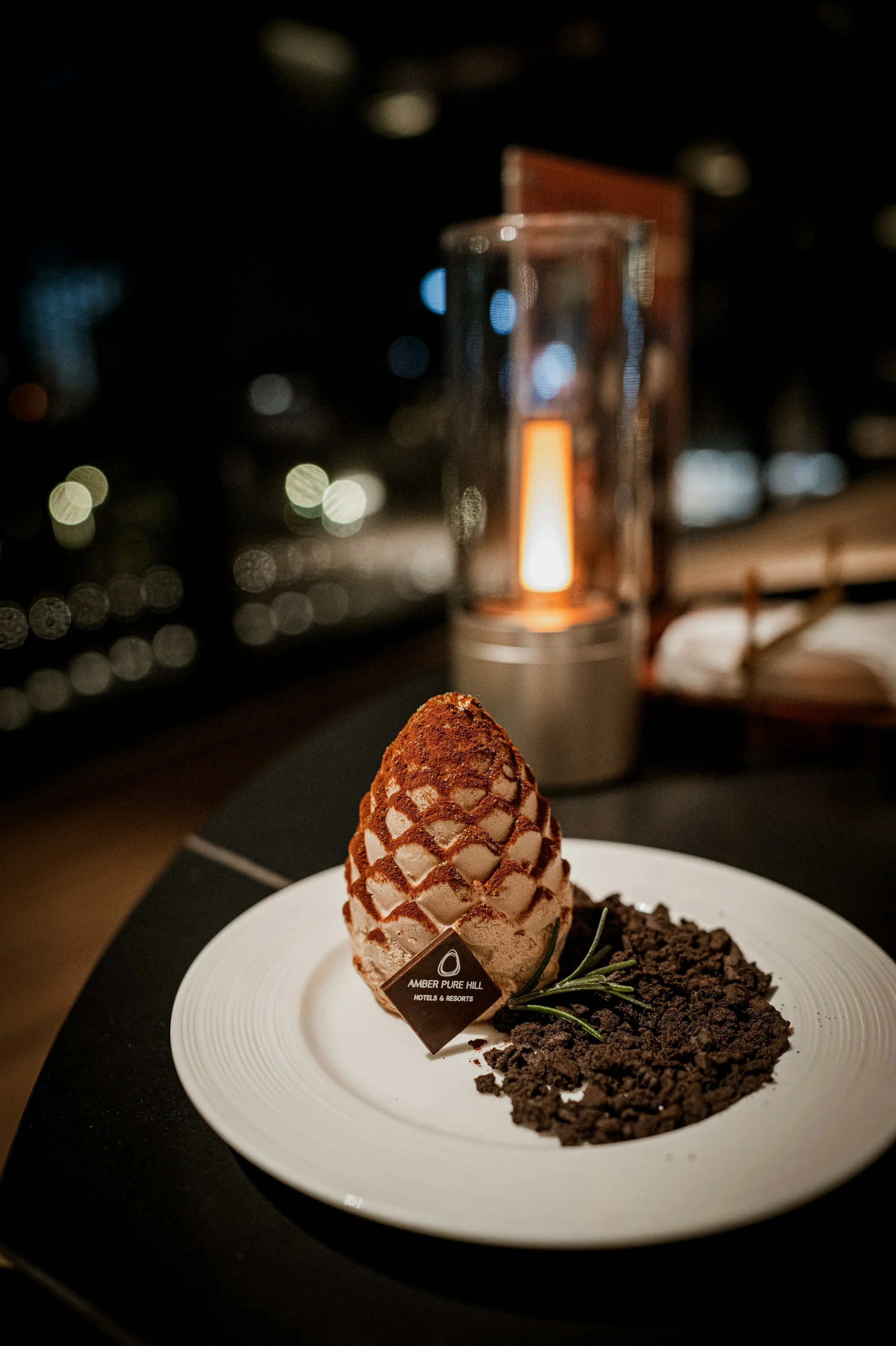 Pinecone-shaped chocolate dessert on a candlelit table