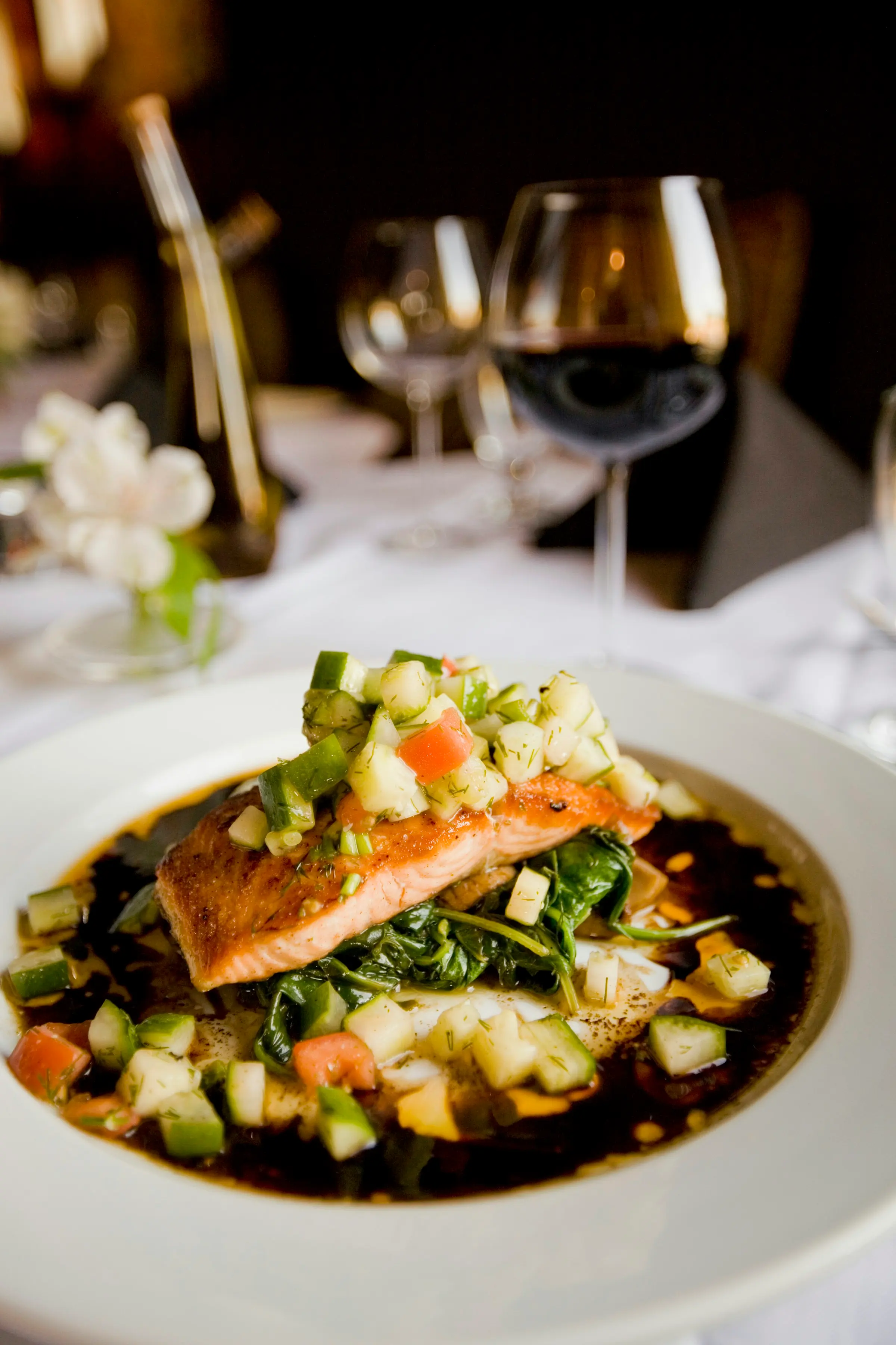 Pan-roasted salmon on a dressed table with wine glasses