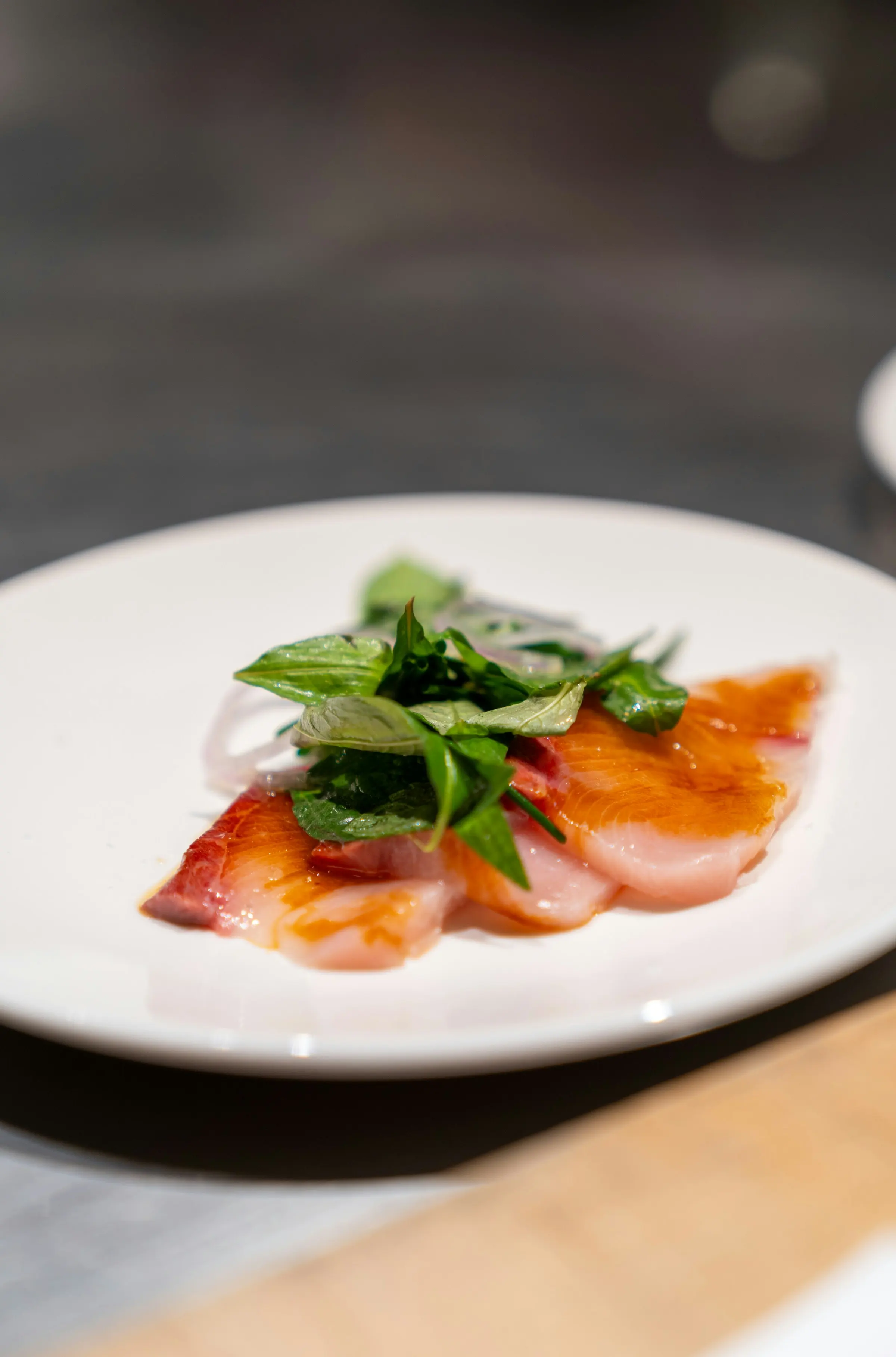 Sliced raw fish crudo with fresh herbs
